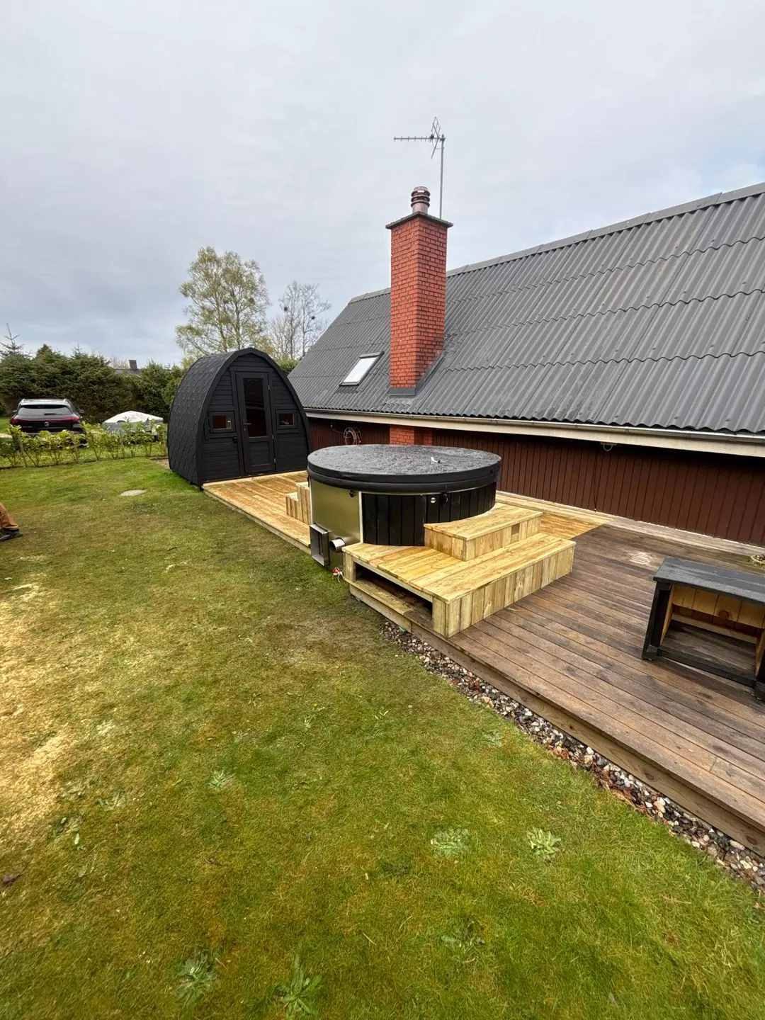 Kompakt træterrasse bygget omkring et vildmarksbad i haven