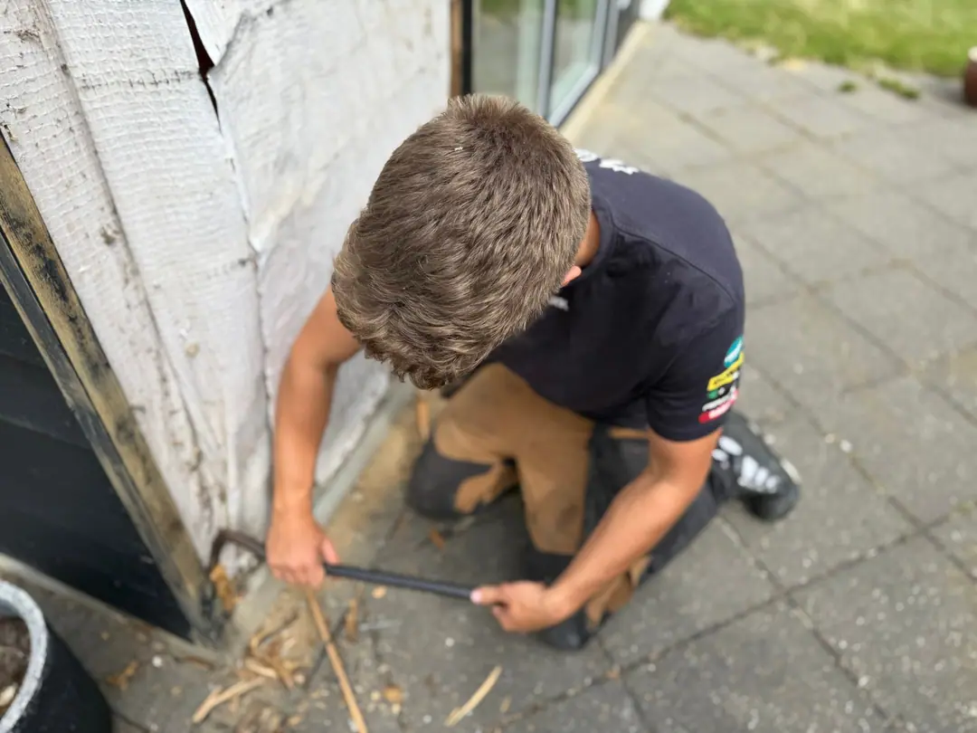 Udskiftning af rådne brædder nederst på en træfacade